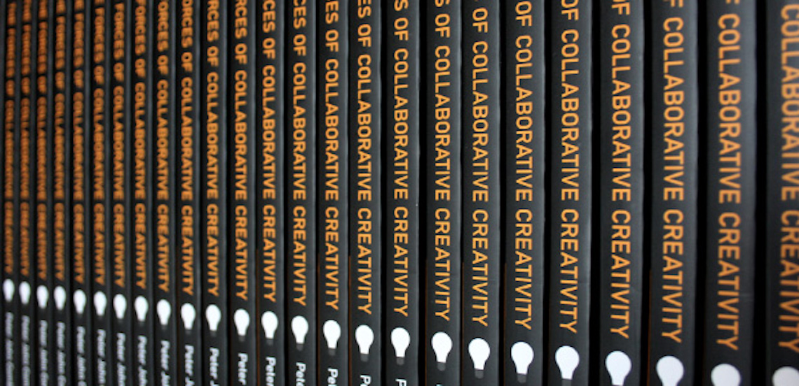 A long row of copies of the book 'The Forces of Collaborative Creativity' by Peter John Comber